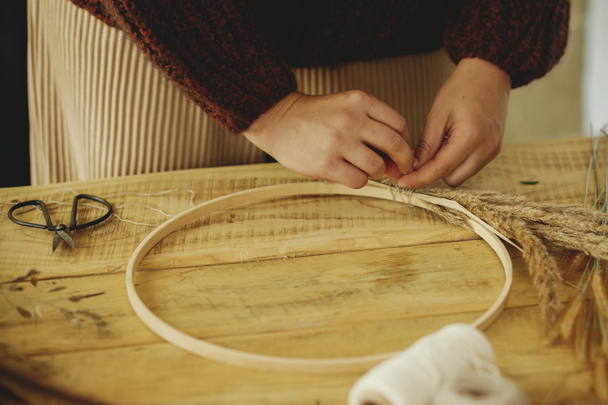 portrait: lead artisan stitching at hoop